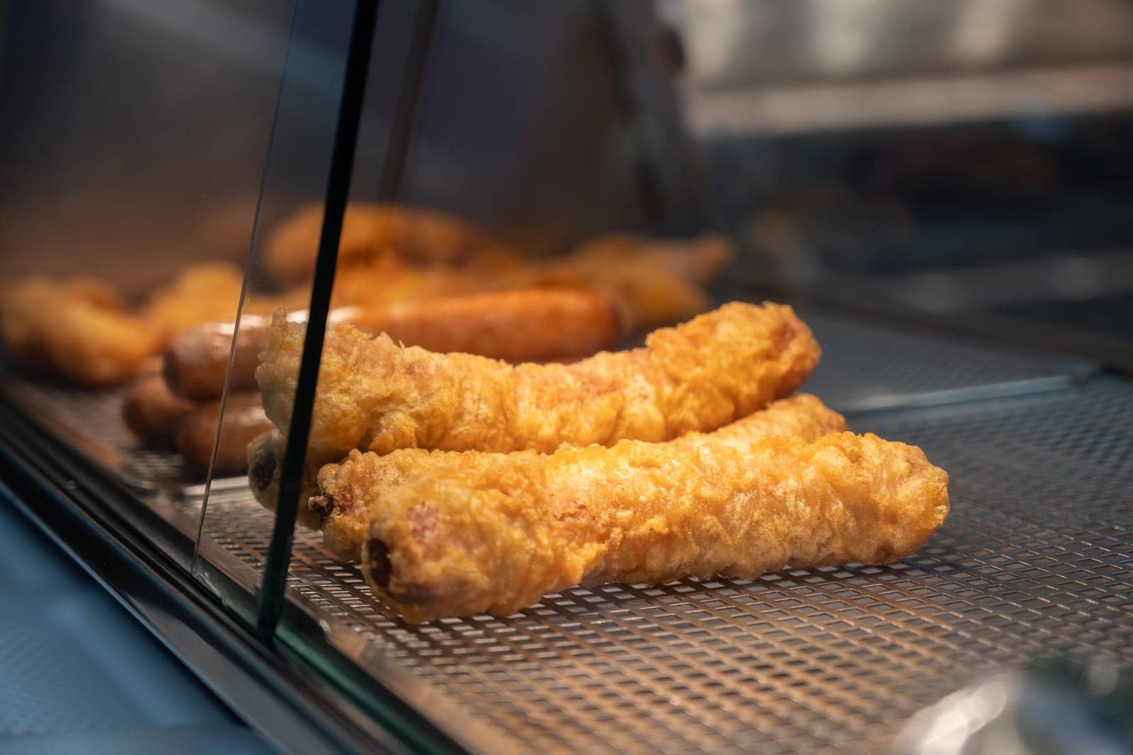 Freshly battered fish resting in the heated display at the takeaway counter