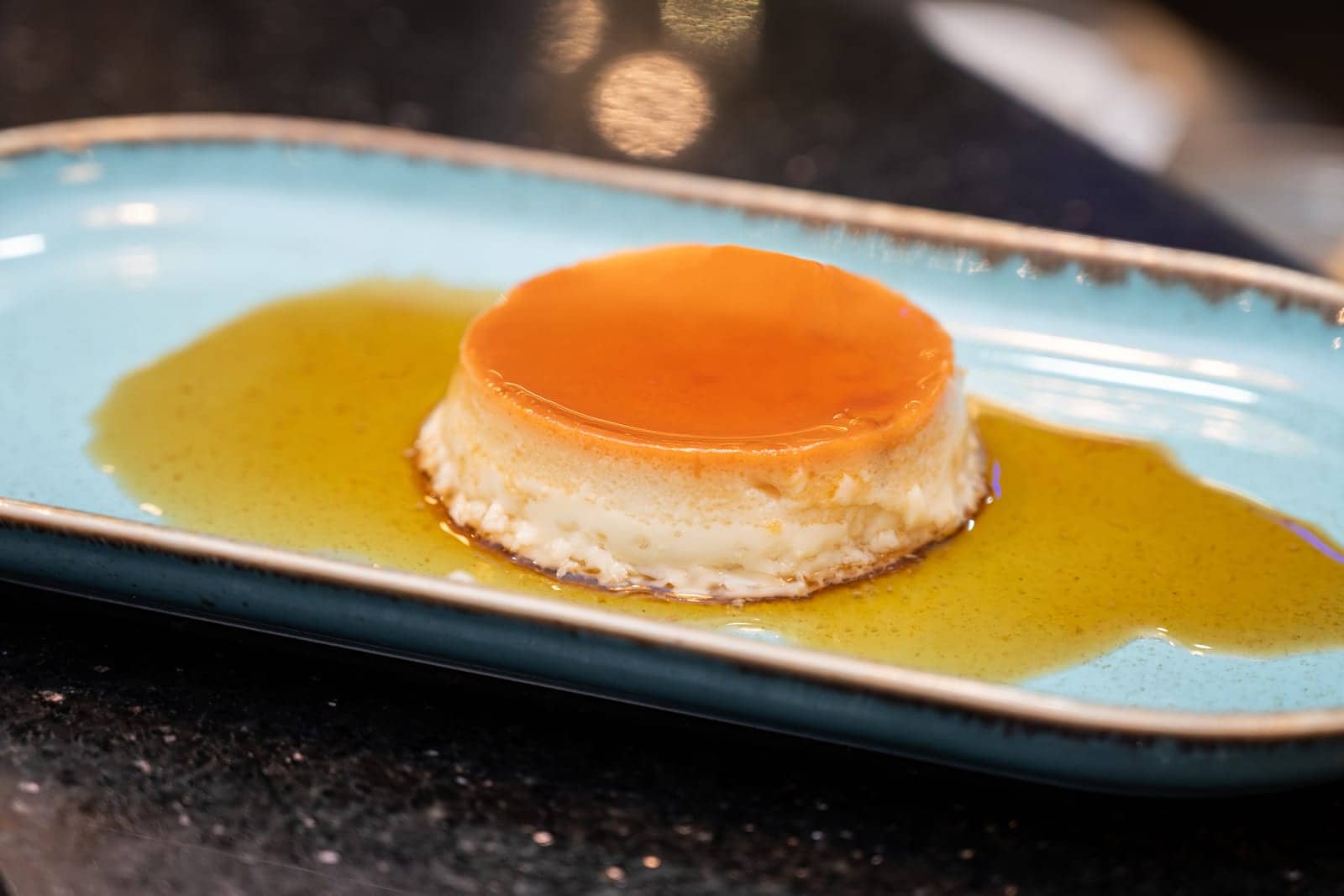 Homemade crème caramel on a slate plate