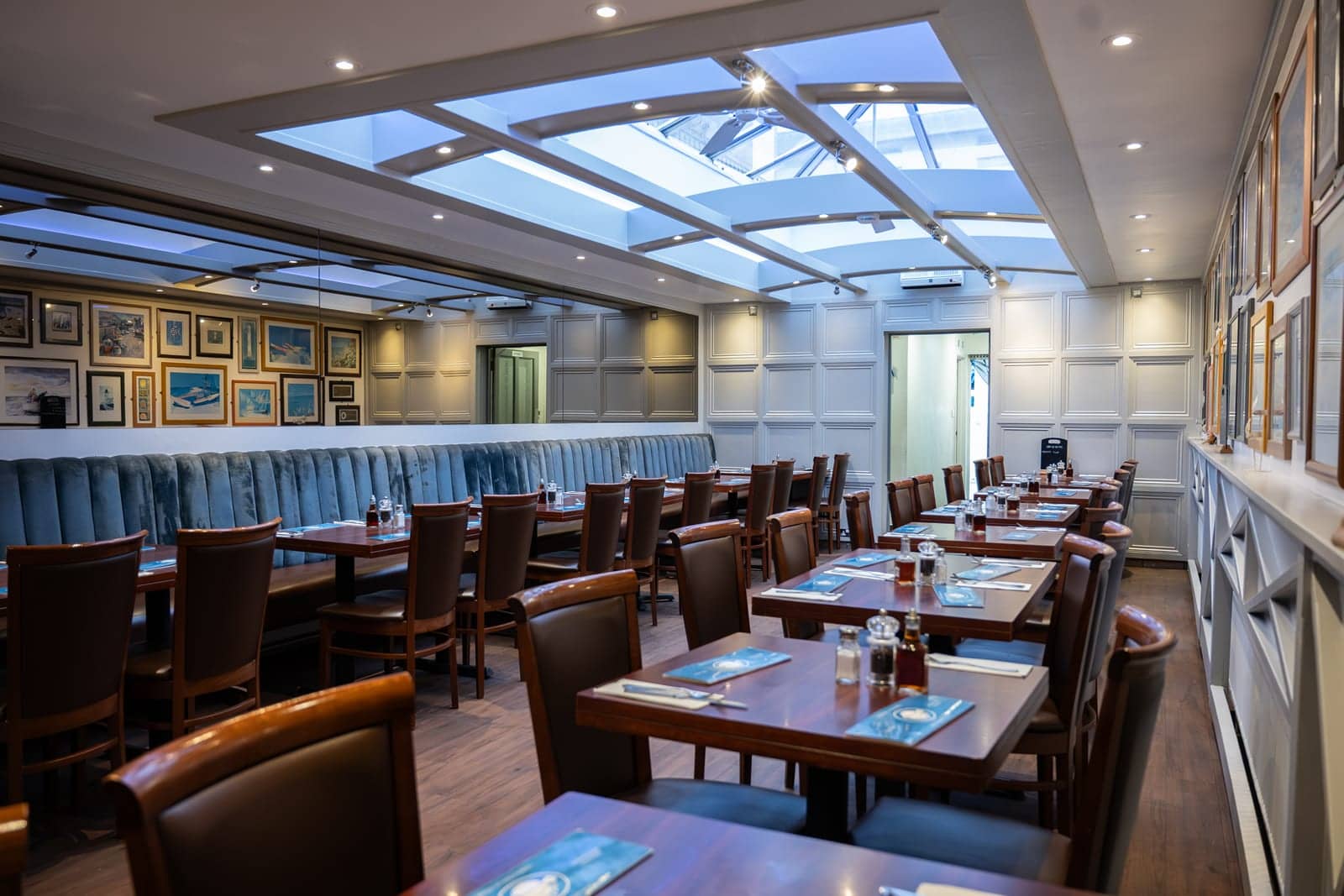 Sea Pebbles dining room under the skylight, tables laid for lunch