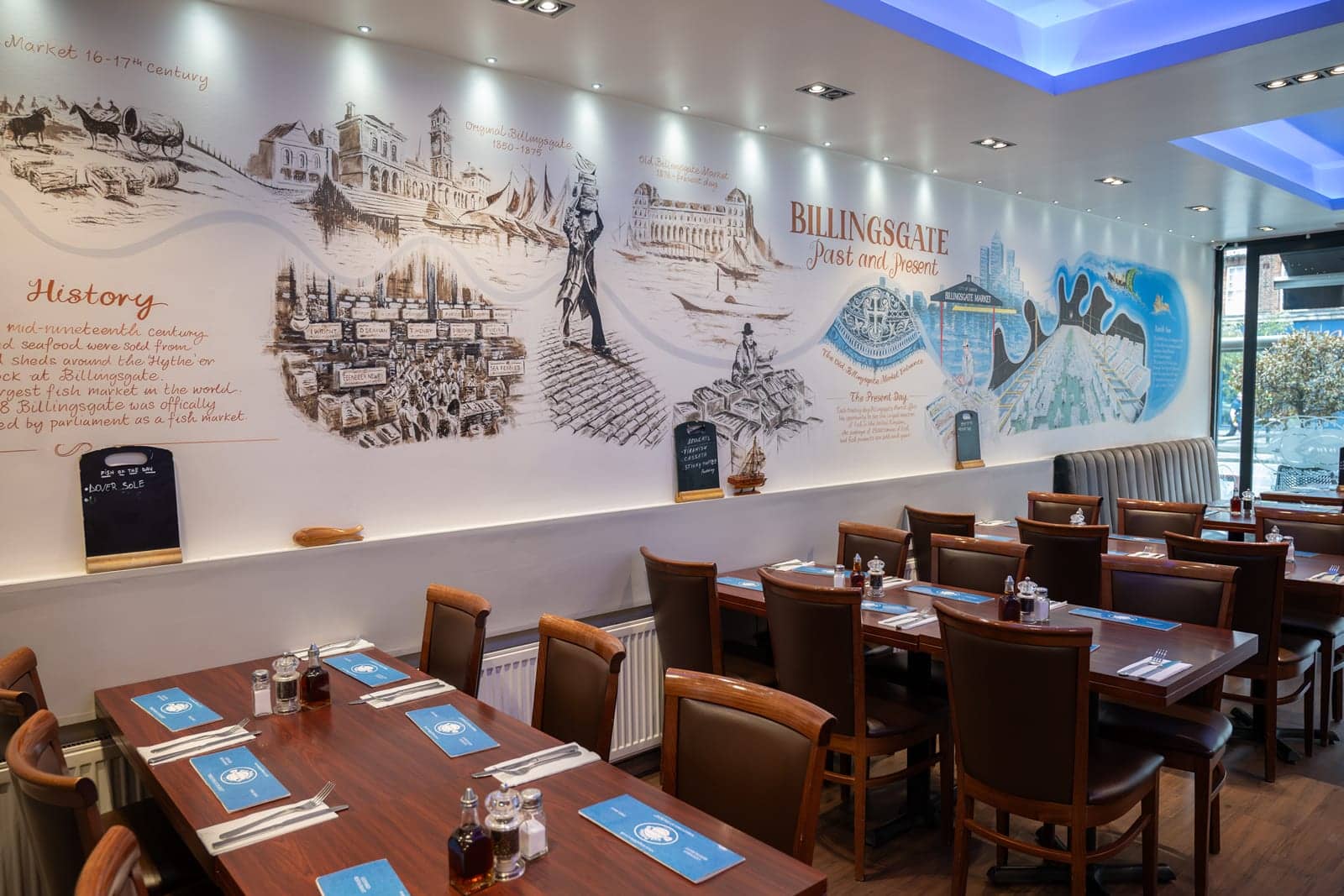 Leather banquettes and wooden tables beneath the Billingsgate mural