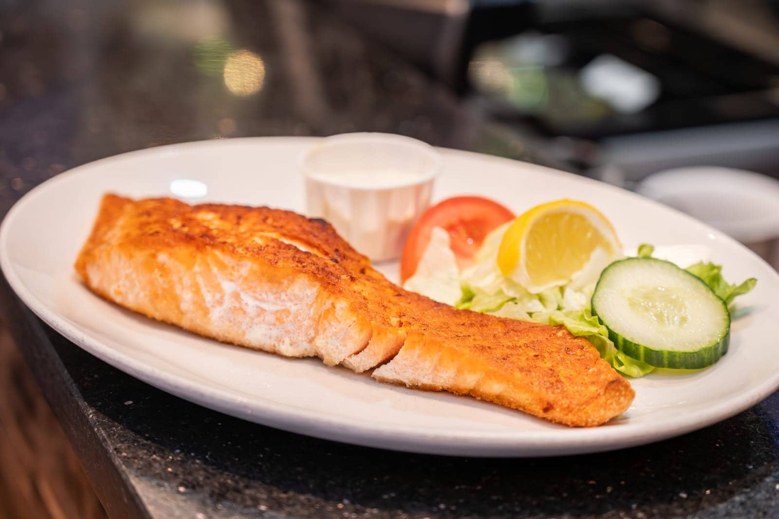 Grilled Scottish salmon fillet with lemon, cucumber and tomato
