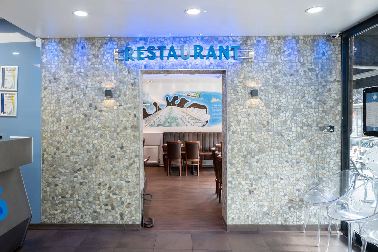The pebble-clad restaurant entrance with its illuminated Restaurant sign