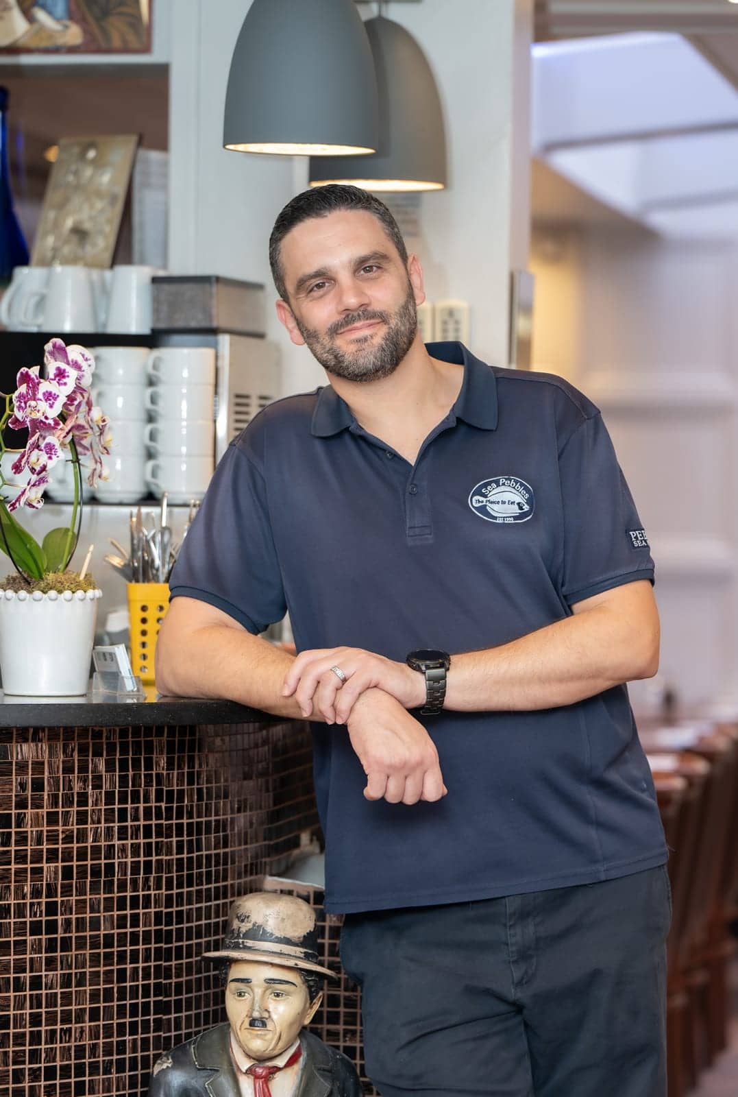 A member of the Sea Pebbles team in the restaurant polo shirt